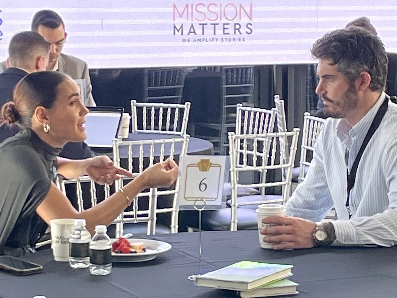 Two attendees having a one-on-one conversation at a conference table
